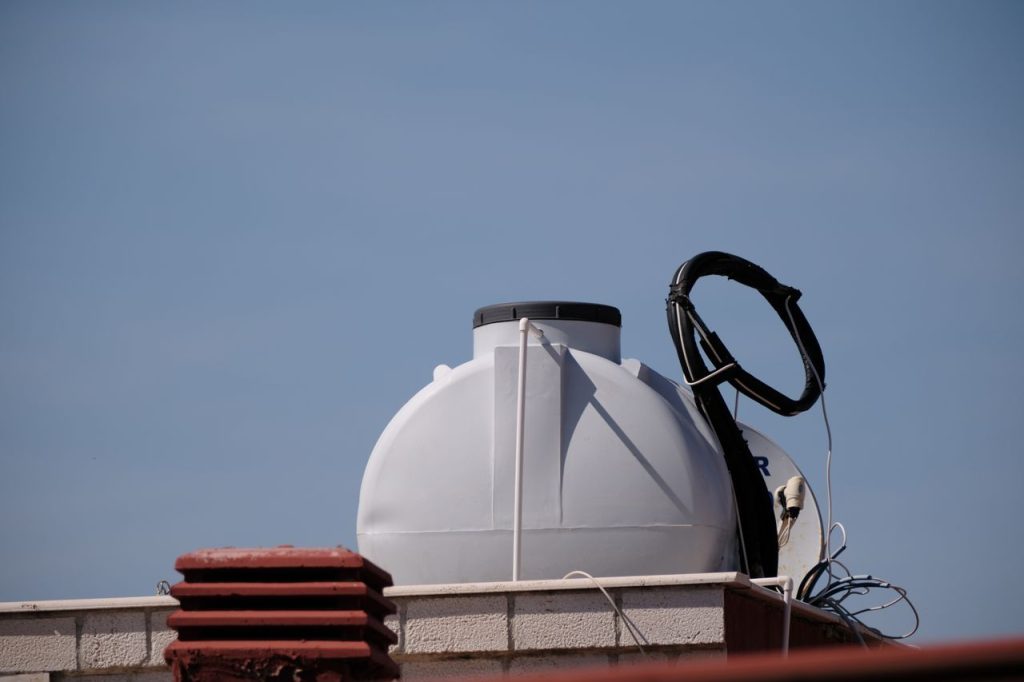 Close-up of a rooftop water tank in Foça, İzmir against a clear blue sky.